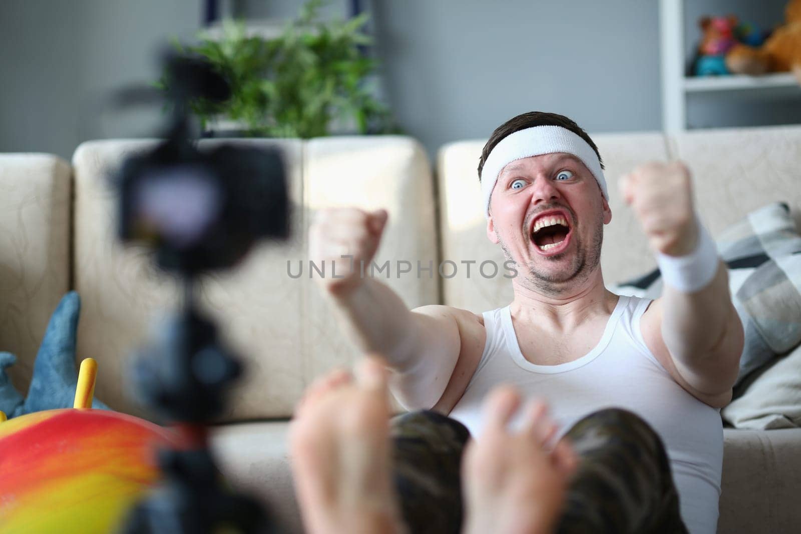 Motivated stubborn emotional man doing sports exercises in front of camera. Complexity of home fitness training and goal of losing weight