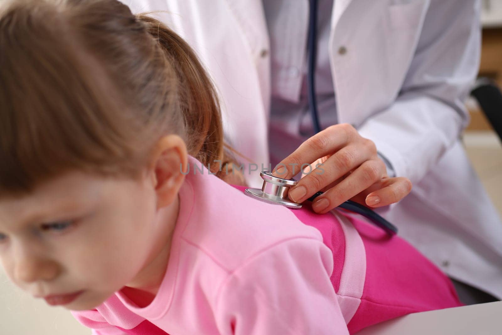 Little girl at doctor lung area examined with stethoscope. Cough bronchitis and asthma in children