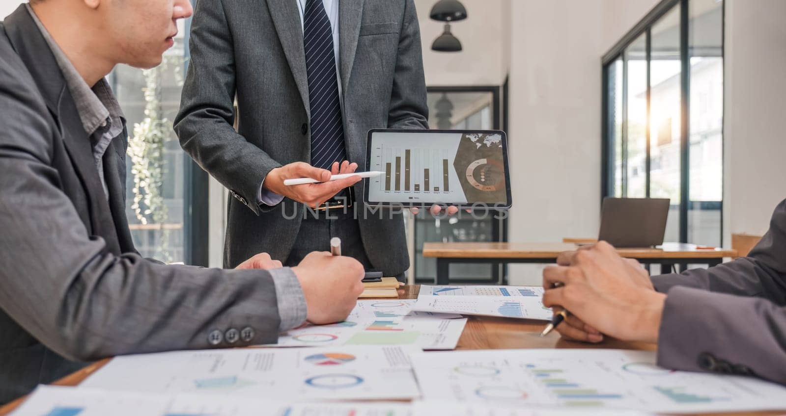 Business People Meeting using laptop computer,calculator,notebook,stock market chart paper for analysis Plans to improve quality next month. Conference Discussion Corporate Concept