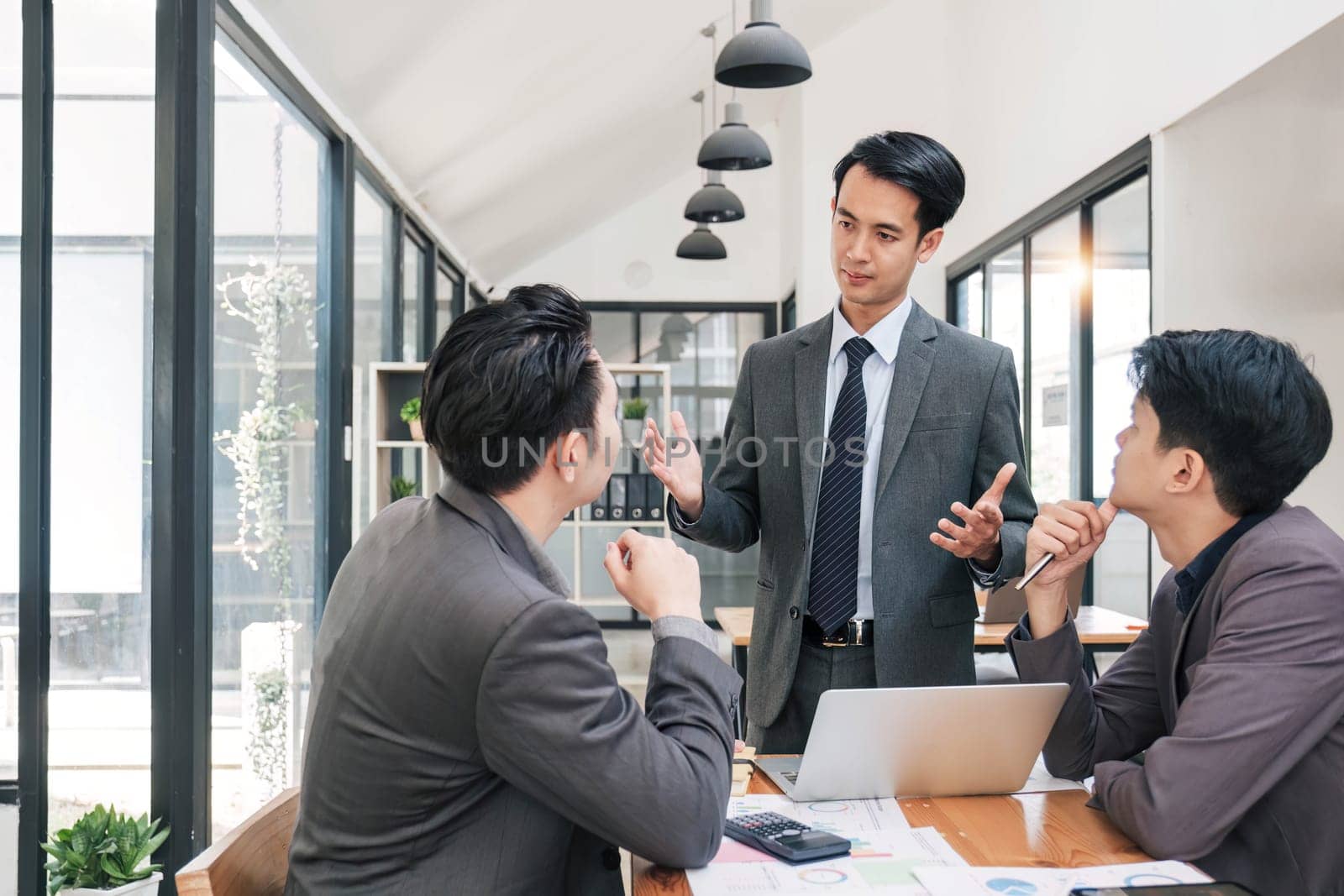 Business People Meeting using laptop computer,calculator,notebook,stock market chart paper for analysis Plans to improve quality next month. Conference Discussion Corporate Concept. by wichayada