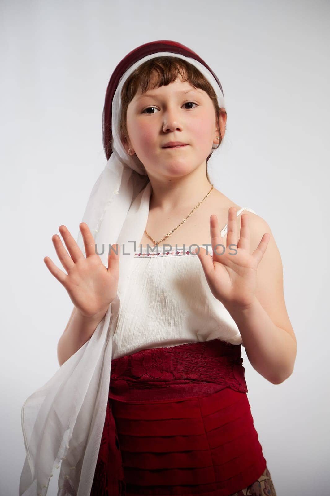 Portrait of Little girl in a stylized Tatar national costume on a white background in the studio. Photo shoot of funny young teenager who is not a professional model