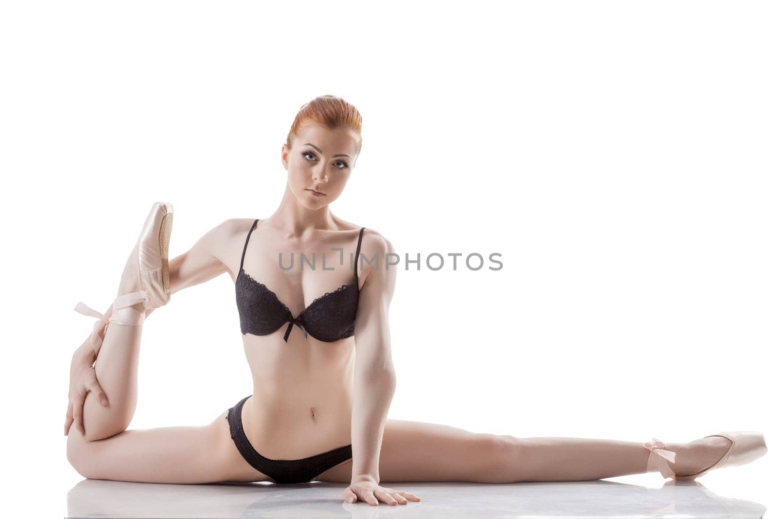 Young flexible red-haired ballerina isolated on white background