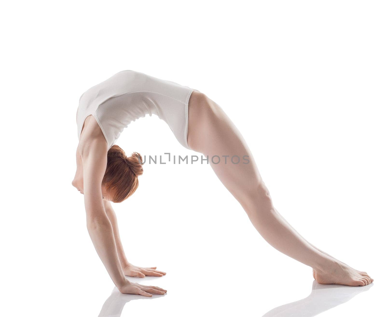 Flexible slim girl doing gymnastic bridge, isolated on white