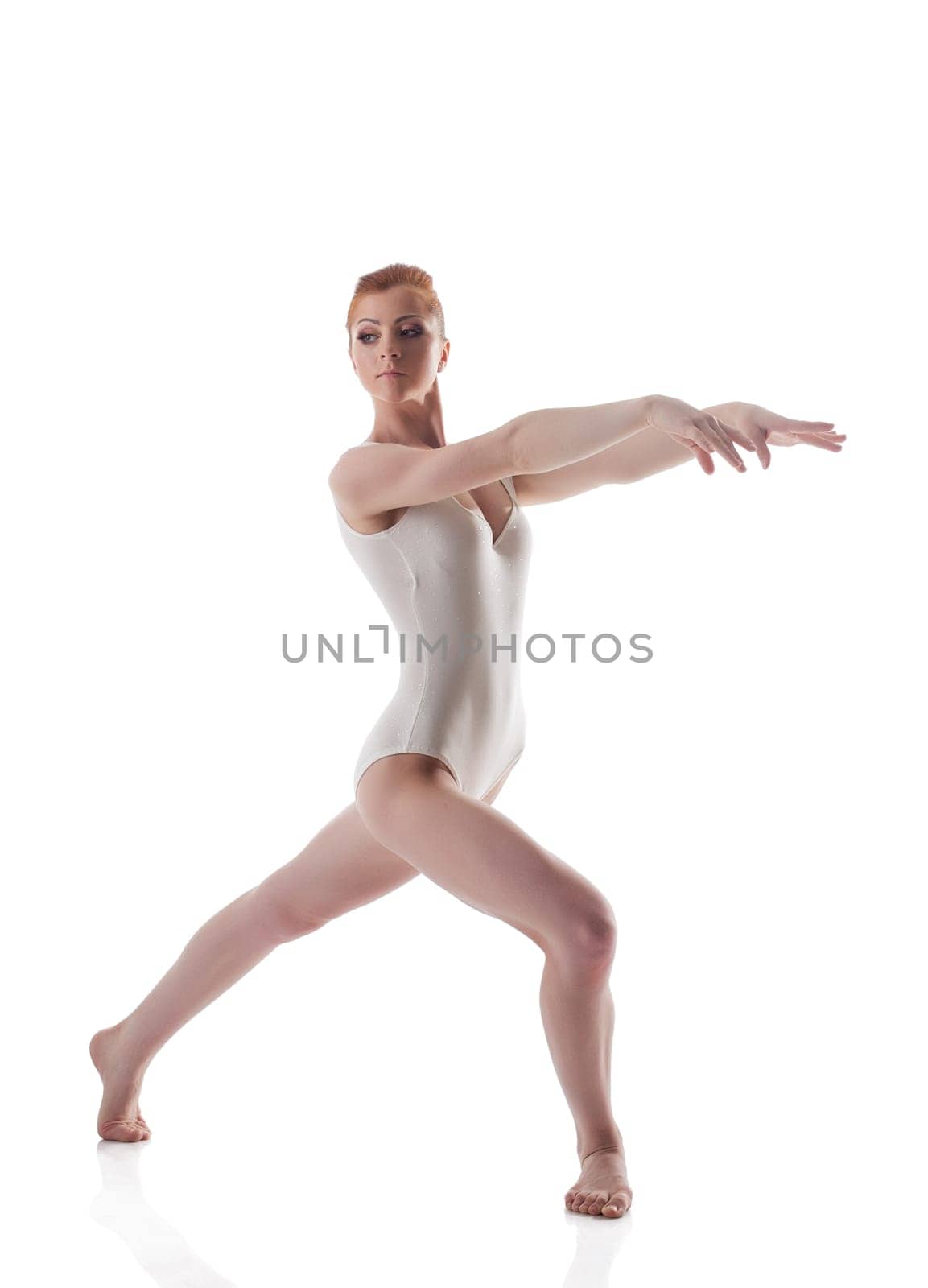 Skinny redhead gymnast posing in leotard, isolated on white background