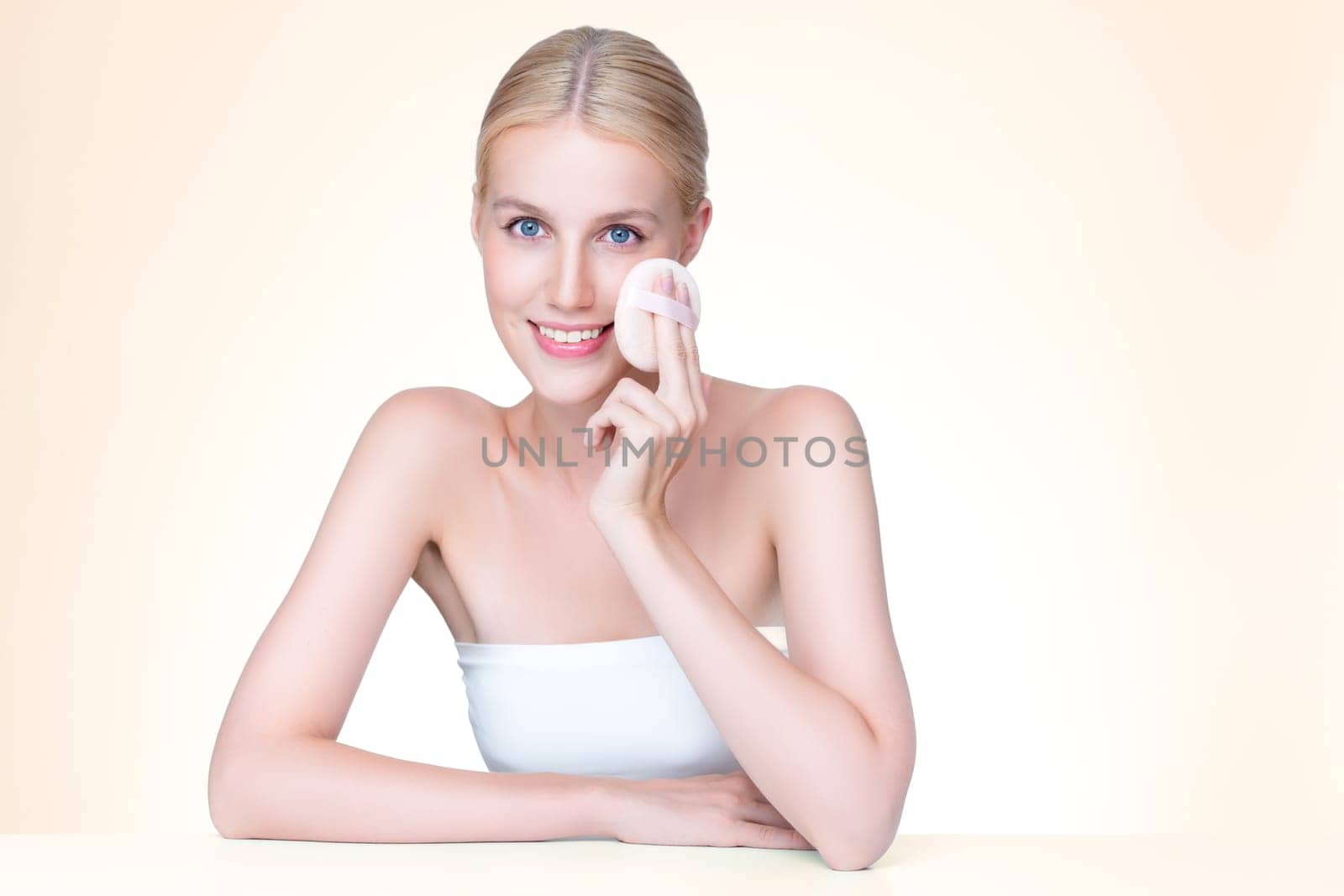 Personable beautiful natural soft makeup woman using powder puff for facial makeup concept. Cushion foundation applying on young girl face in isolated background.