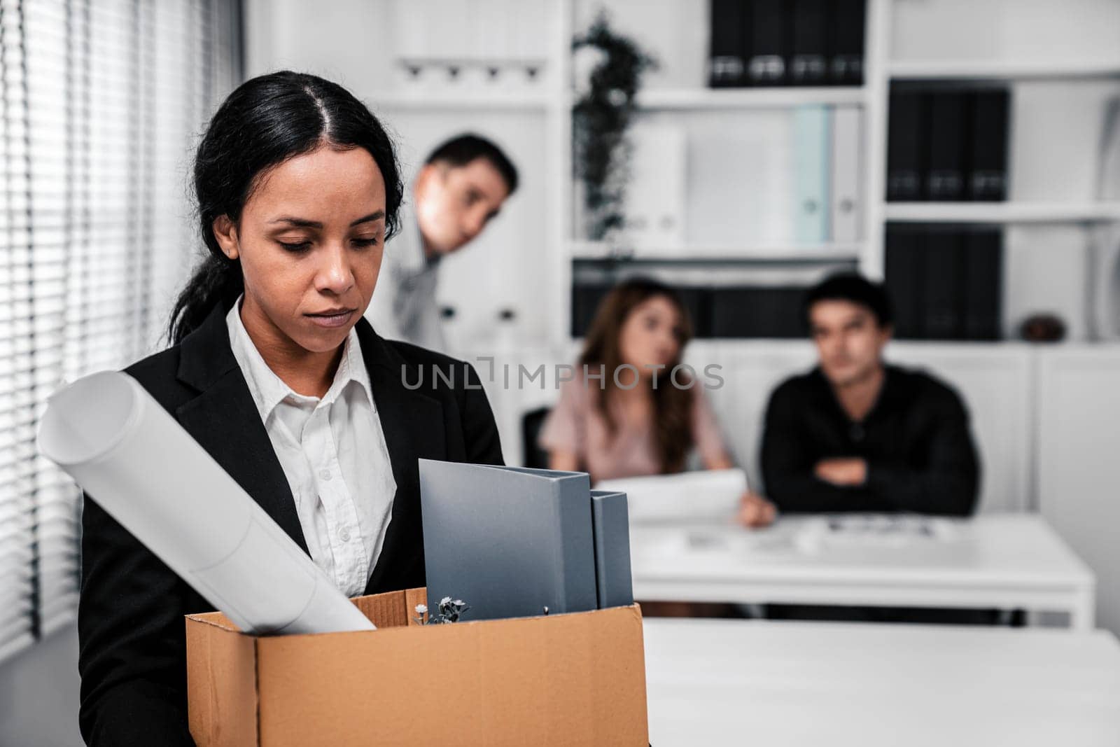 Depressed and disappointed employee packing her belongings after being fired for not being competent. Gossiped by her colleagues behind his back. Layoff due to economic depression.