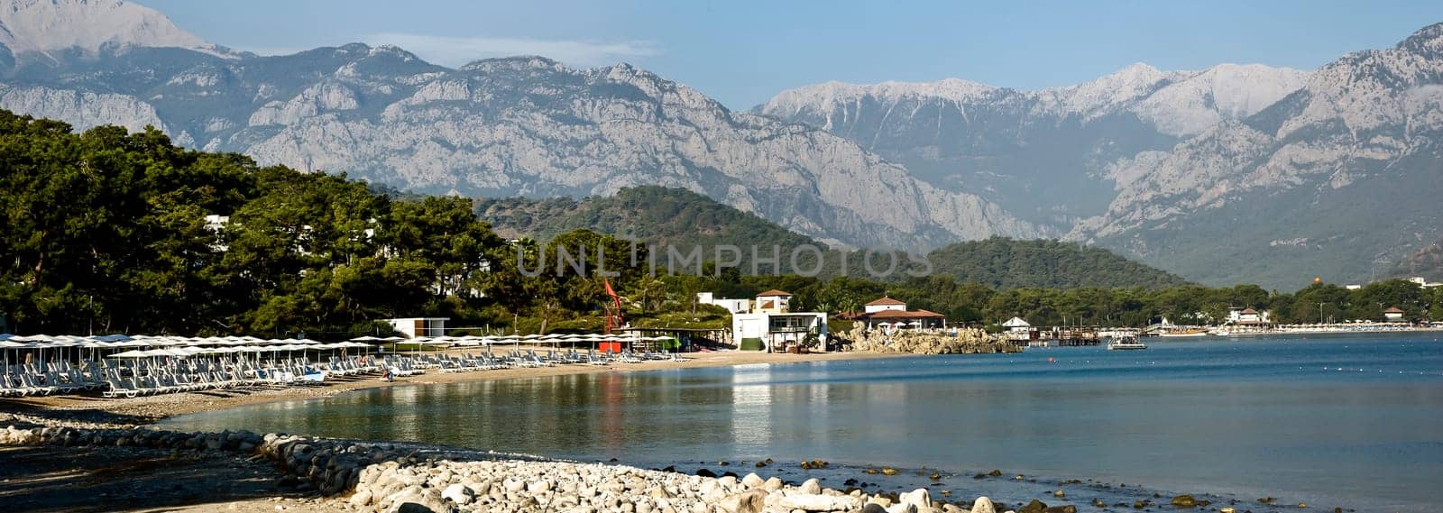 Kemer Antalia nice view of the sea. Beach Kemer Antalia with sand and mountains, the sea with the ship. Beautiful harbor near the sandy beach.