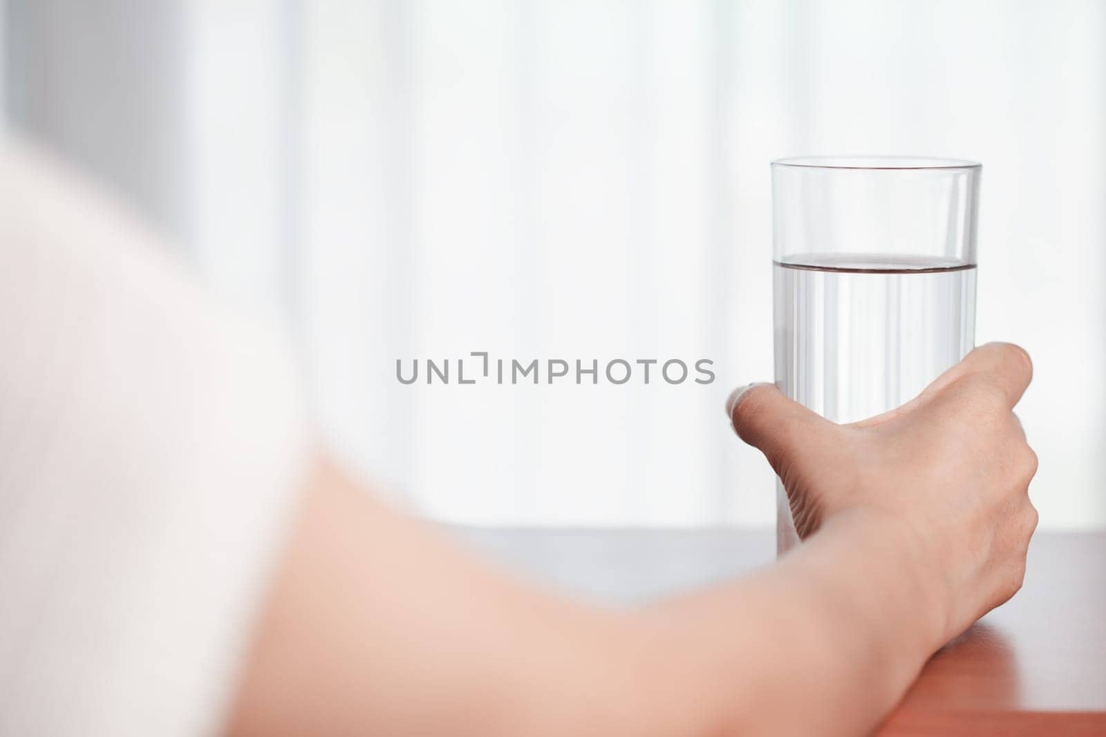 Asian woman's hand holding glass of drinking water for drinking and beverages concept.