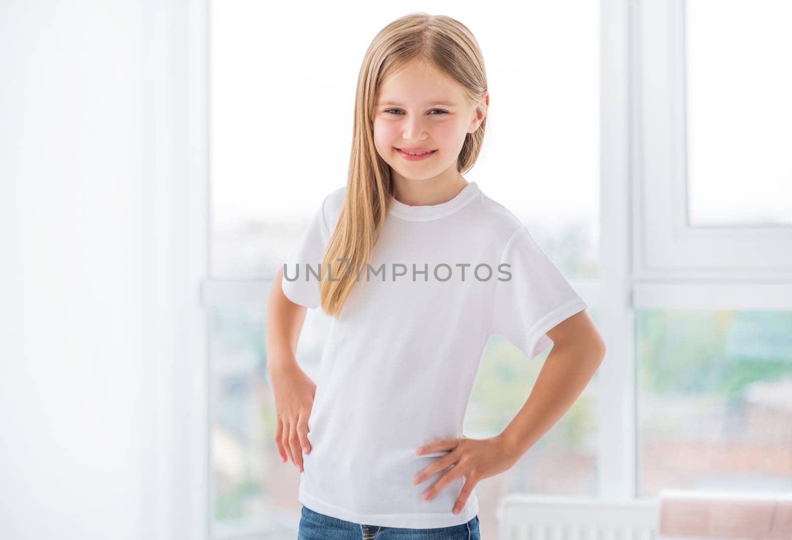 Smiling little girl in white t-shirt in room