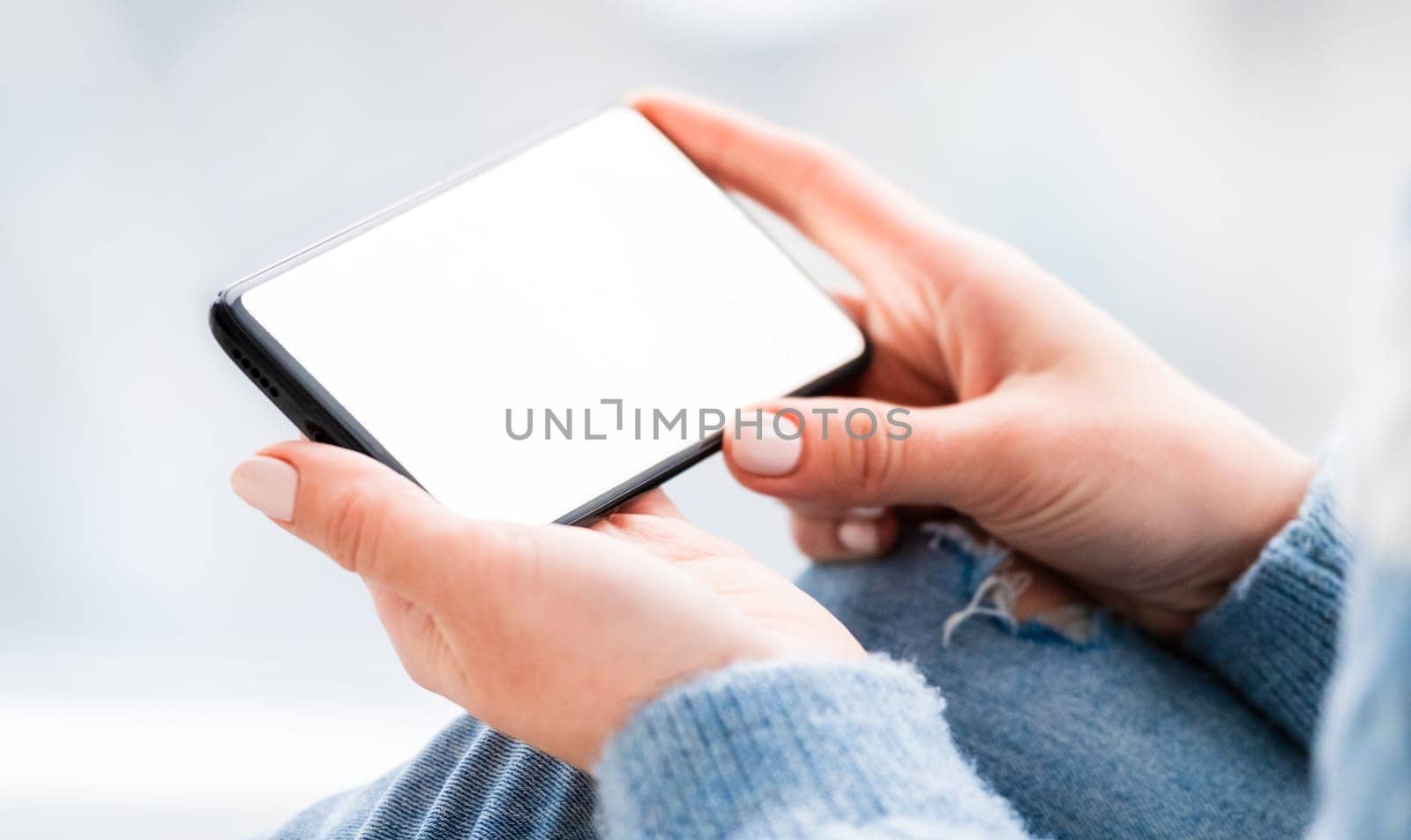 Hand holding mobile phone with white screen