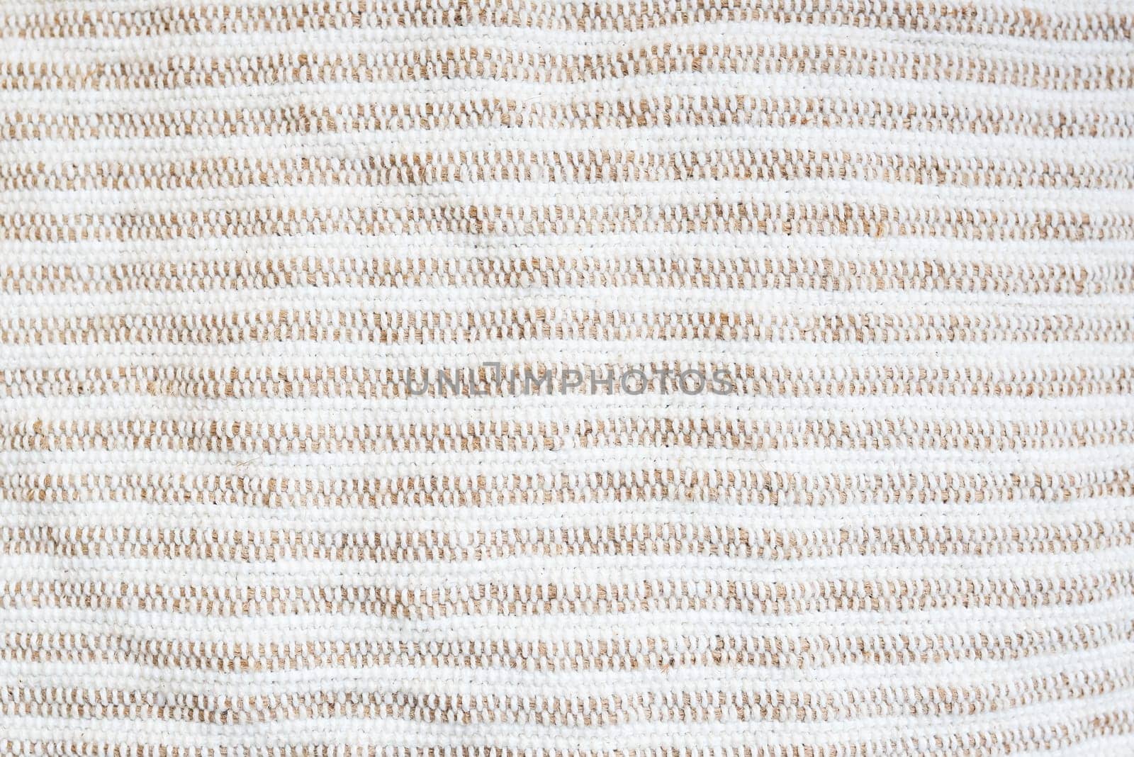 Beige-white striped background, rough fabric, close-up. Selective focus. by sfinks