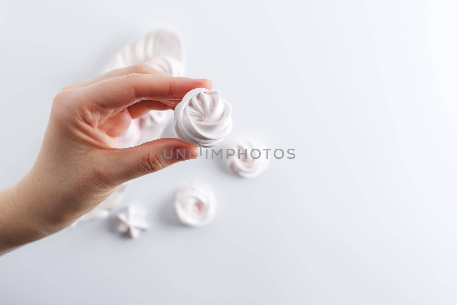 Meringue. Light dessert of whipped egg whites in a female hand .copy space