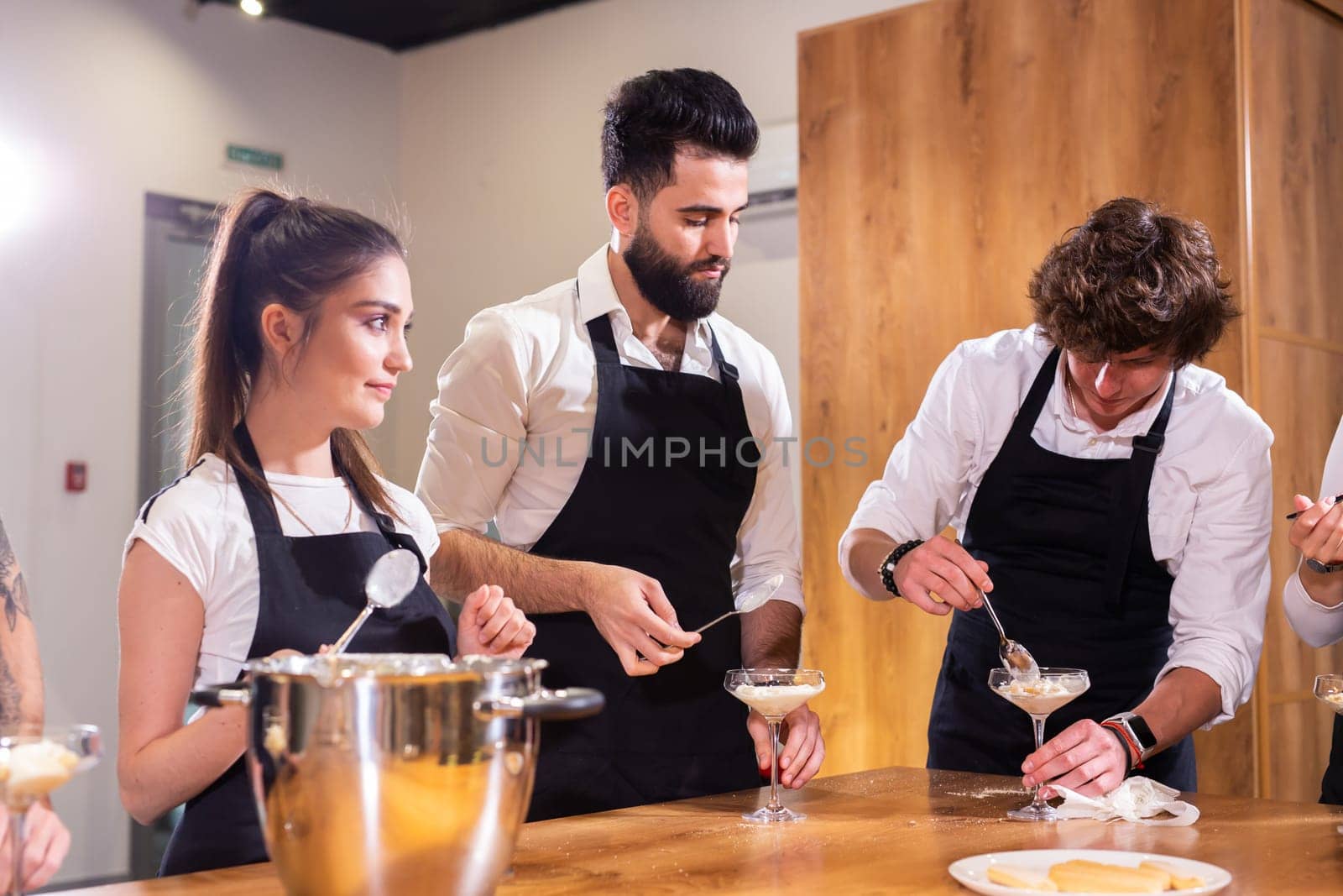 Chef teaching trainees how to make ice cream. Cooking tasty ice cream dessert made from chocolate and vanilla in glass bowl by Satura86