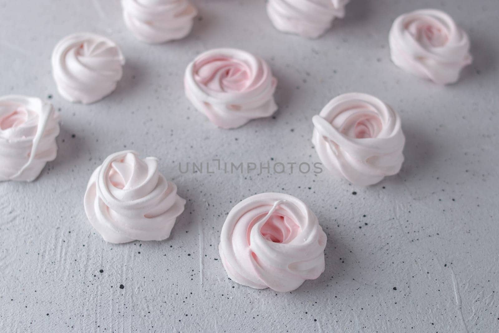 Meringue. Light dessert of whipped egg whites on a gray background.