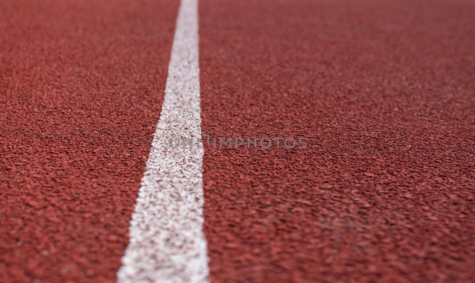 Red plastic covering on the playground, white stripe. Preparing for the competition. Place for an inscription