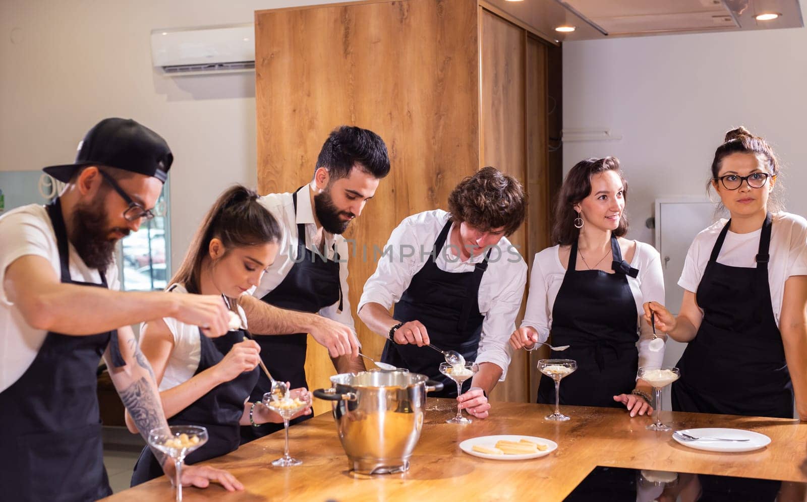 Chef teaching trainees how to make ice cream. Cooking tasty ice cream dessert made from chocolate and vanilla in glass bowl by Satura86