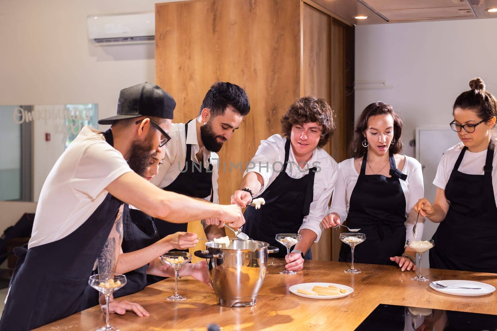 Chef teaching trainees how to make ice cream. Cooking tasty ice cream dessert made from chocolate and vanilla in glass bowl by Satura86