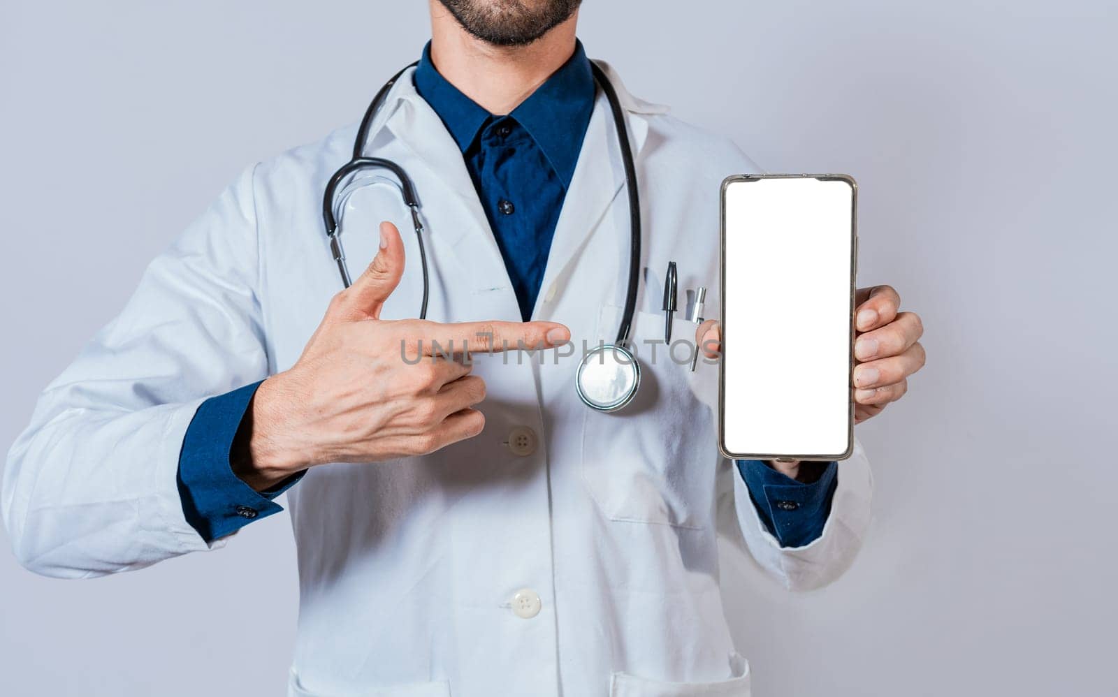 Doctor showing and pointing to blank cell phone screen. Doctor recommending on cell phone screen isolated by isaiphoto