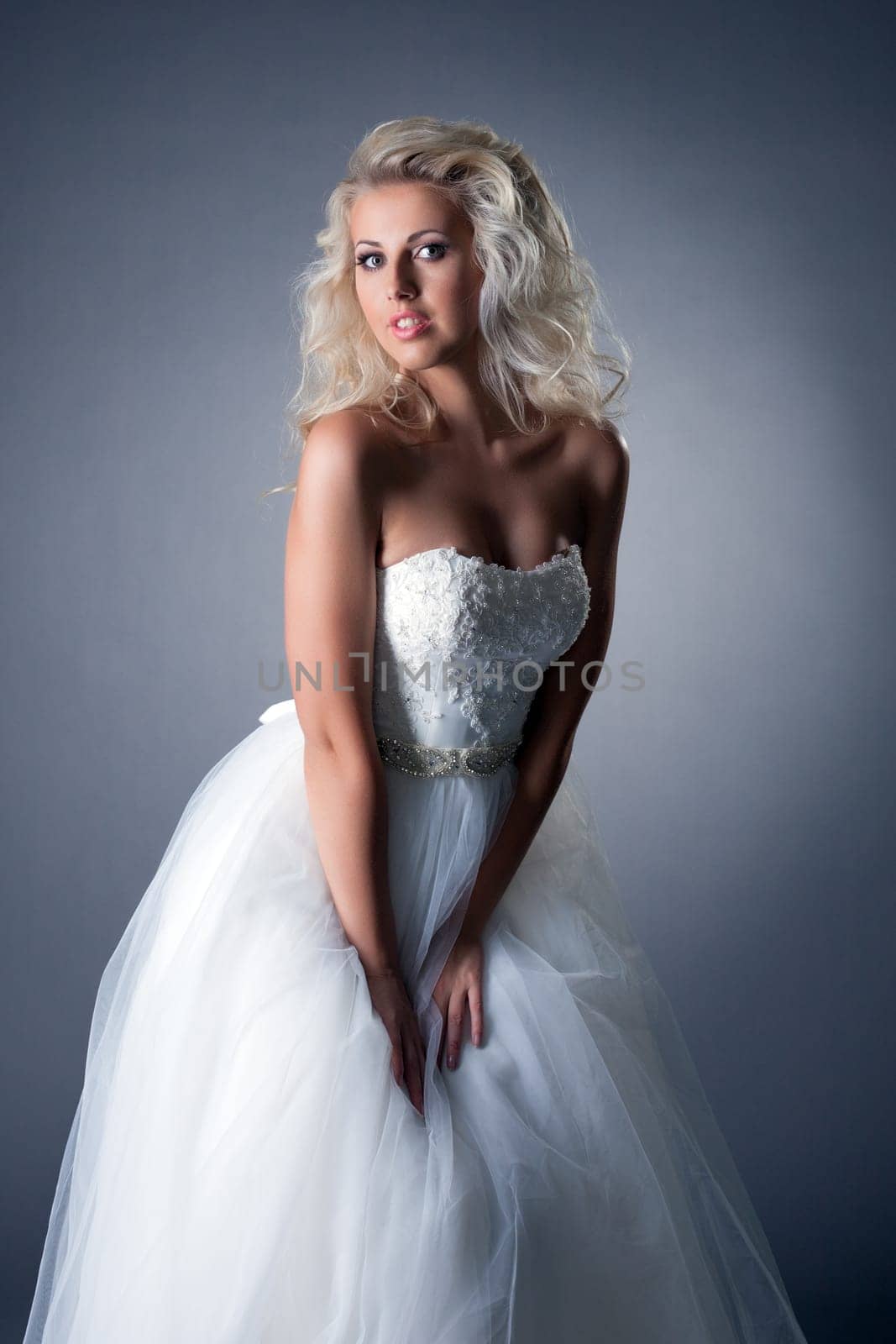 Romantic blonde posing in lush wedding dress by rivertime