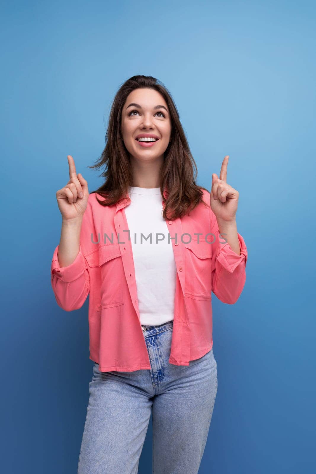 successful joyful brunette woman with hair below her shoulders in a shirt by TRMK