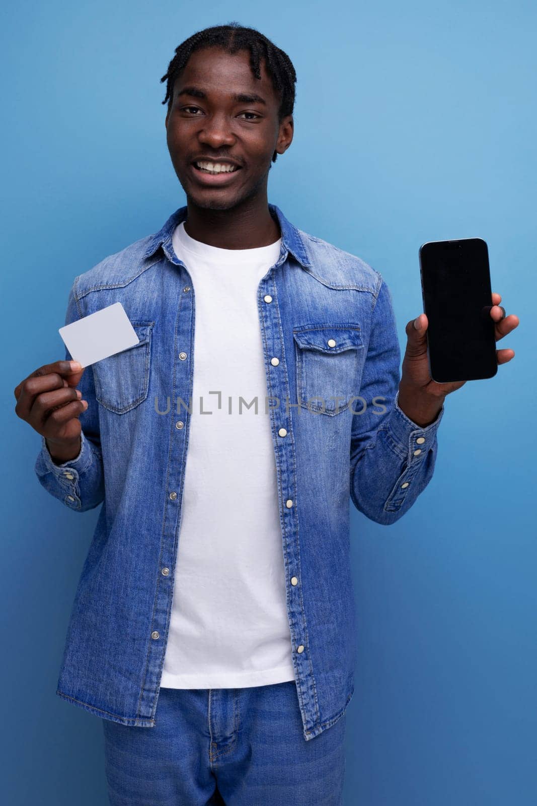 charismatic american man with black dreadlocks making payment with money card and smartphone by TRMK