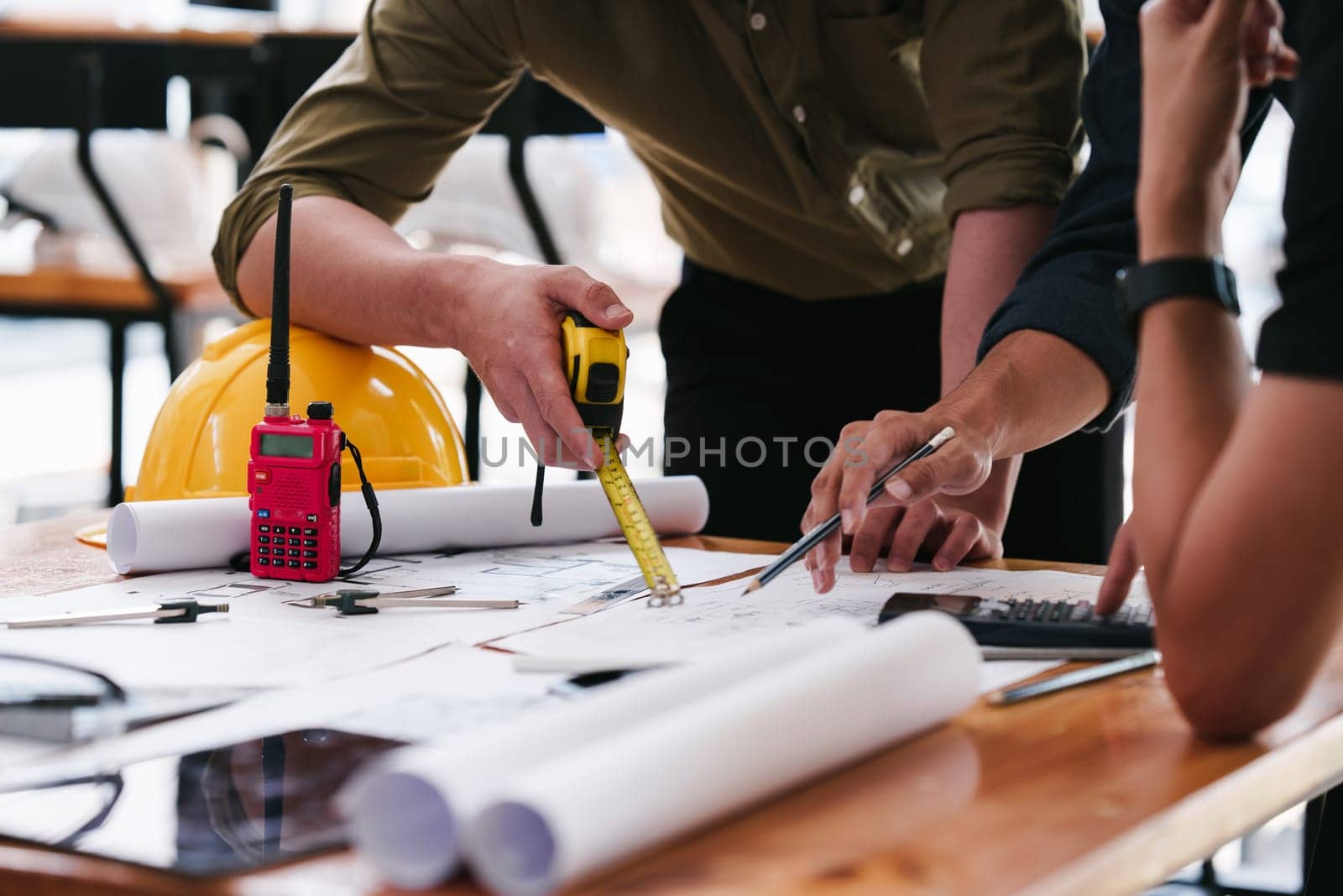 Architect and Engineer working with blueprints for architectural plan, engineer sketching a construction project, green energy concept.