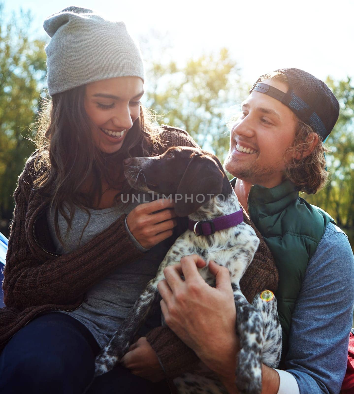 Were one happy family. a couple and their dog spending the day outdoors. by YuriArcurs