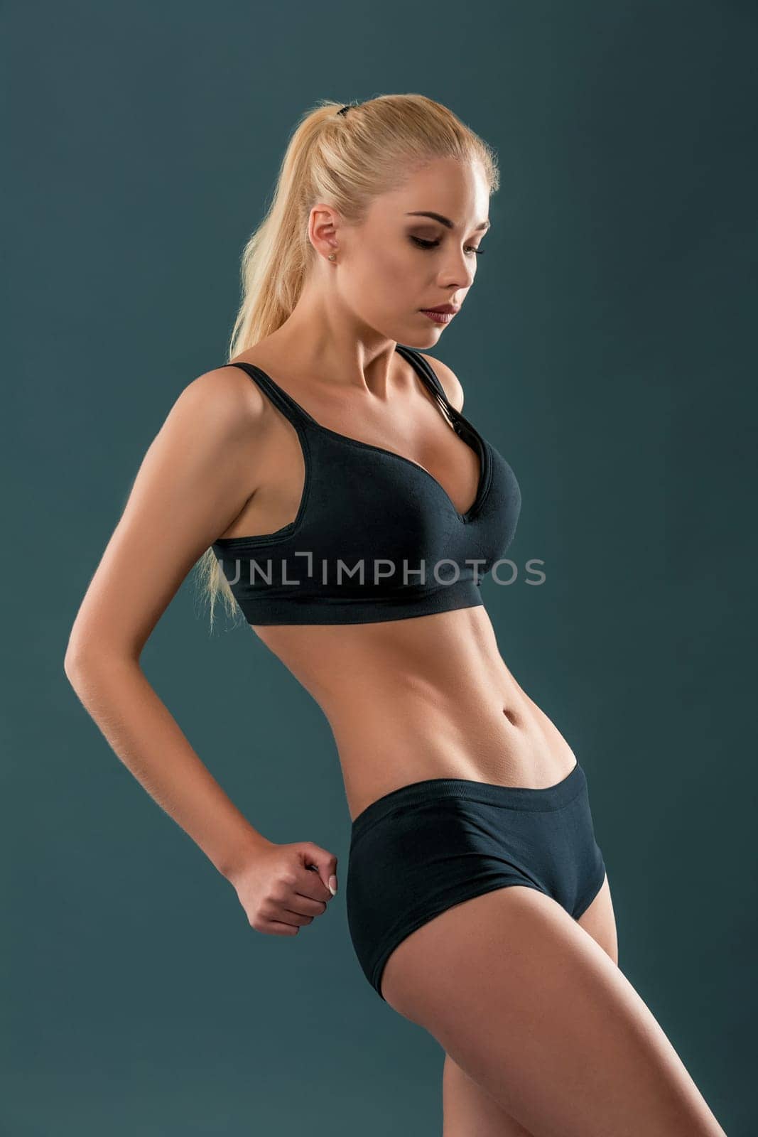 Young beautiful woman in fitness wear trained female body, lifestyle portrait, caucasian model