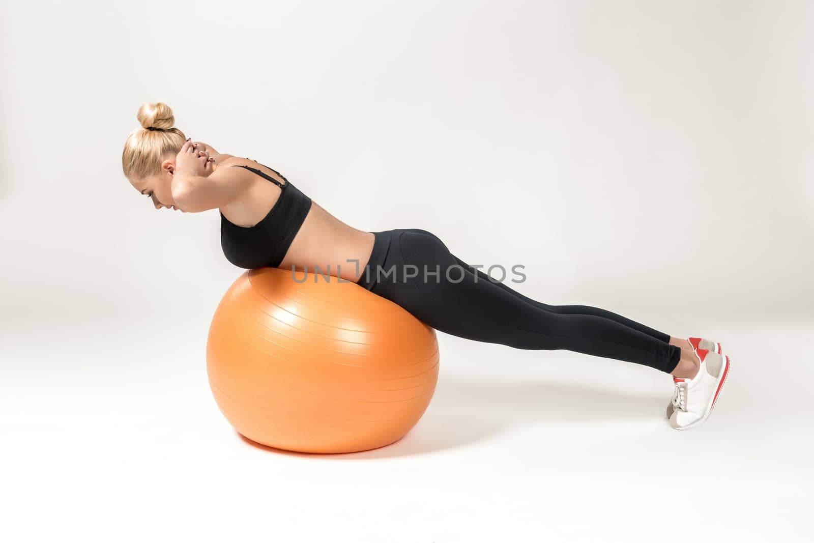 Young blonde woman training with fitball. Fitness exercises for abdomen