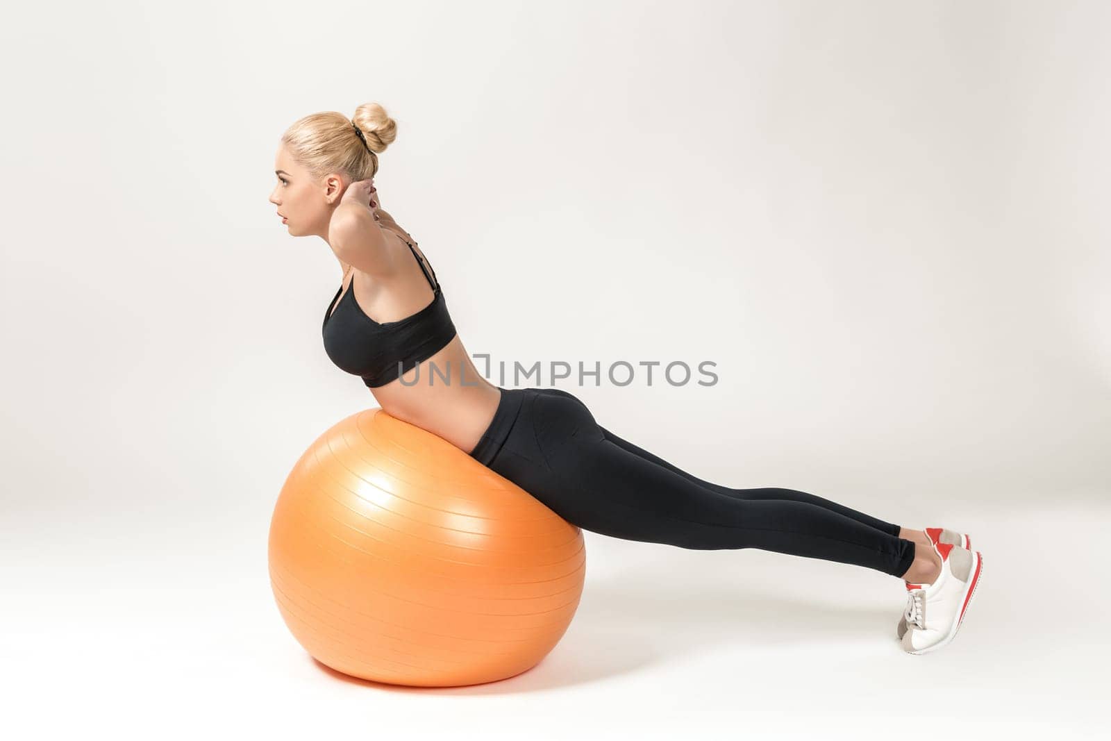 Young blonde woman training with fitball. Fitness exercises for abdomen