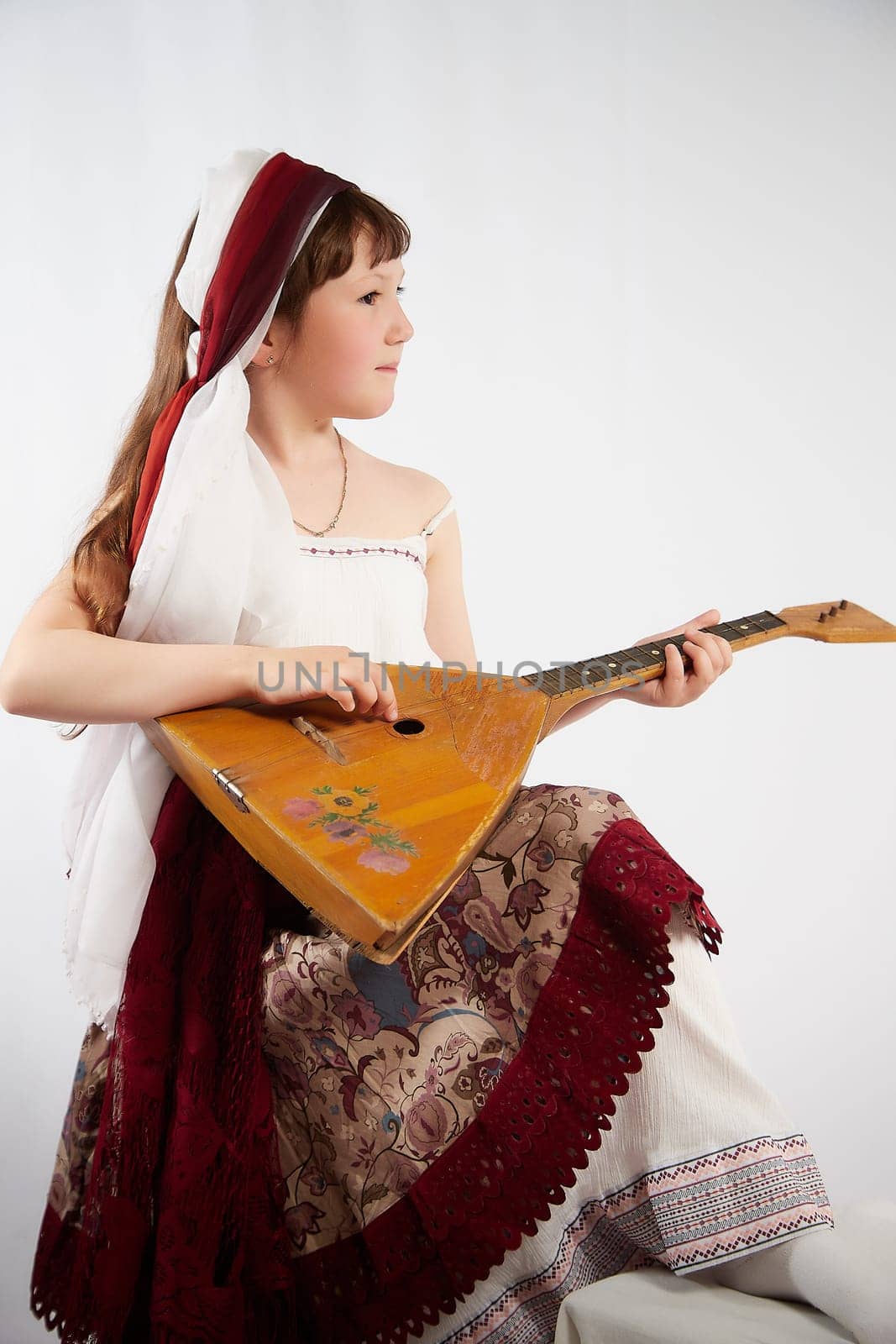 Portrait of Little girl in a stylized Tatar national costume on a white background in the studio. Photo shoot of funny young teenager who is not a professional model