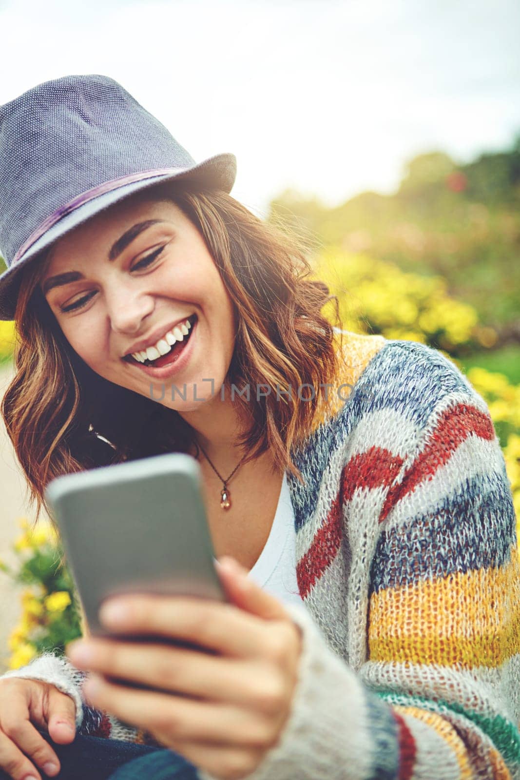 Sharing her day outdoors with her online friends. an attractive young woman using a mobile phone during a spring day outdoors