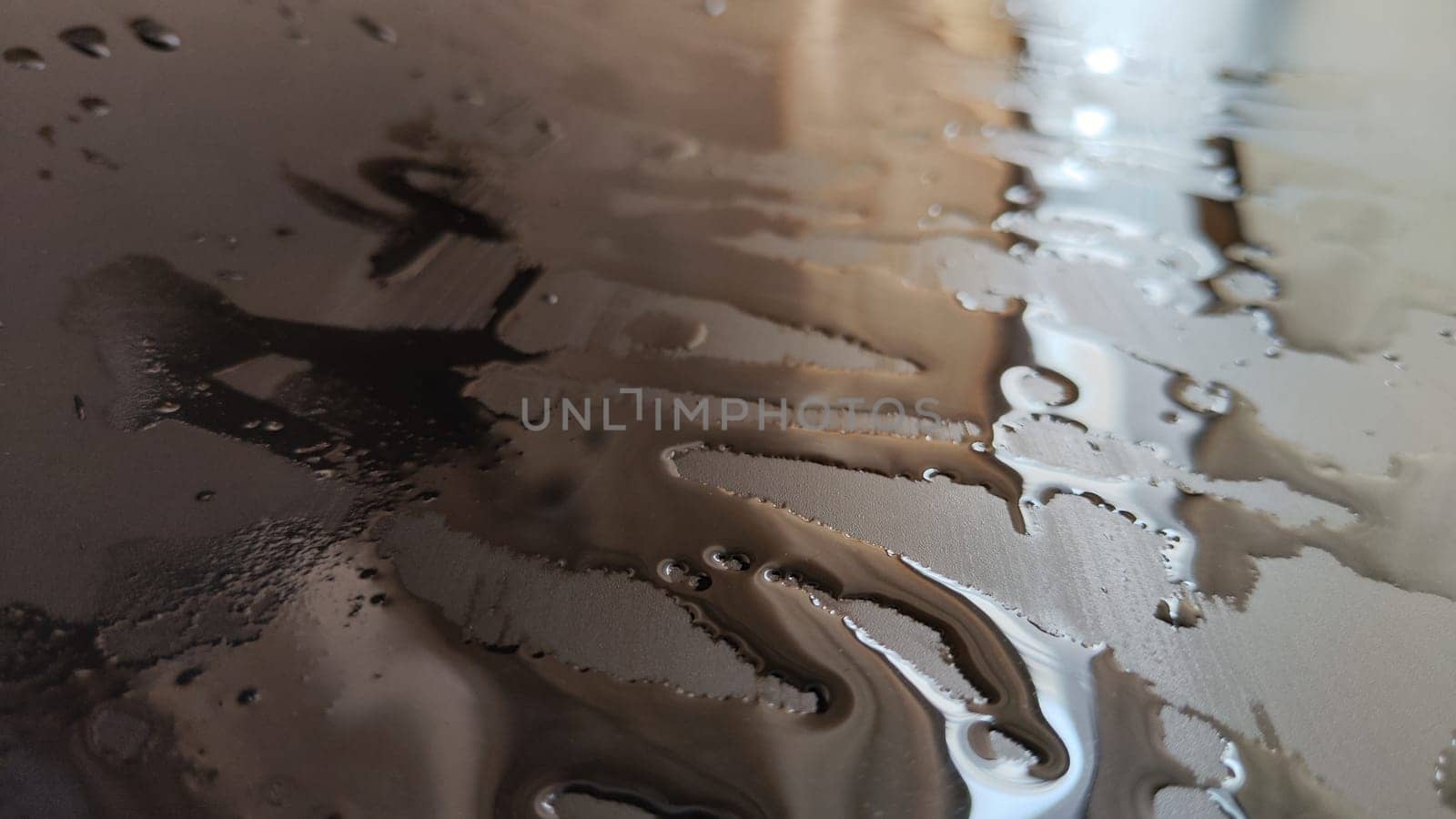 Water drops on black plastic. Surface with wet background. Abstract texture and pattern full of water. Raindrops of rain for overlaying on window with partial focus. Concept of autumn weather