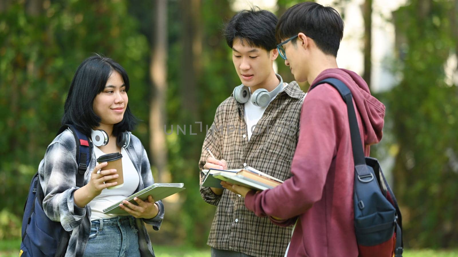 Group of students are talking to each other after classes while walking outdoors in university. Education and youth lifestyle concept.