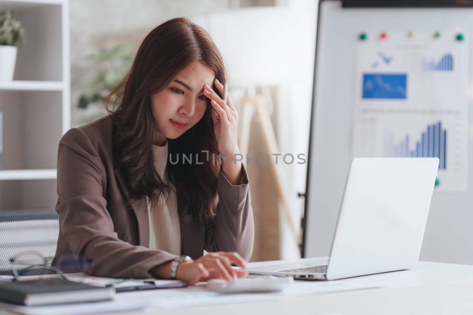 Accountant woman working on laptop and do document look stress, tax, exchange, research, accounting and Financial advisor concept.