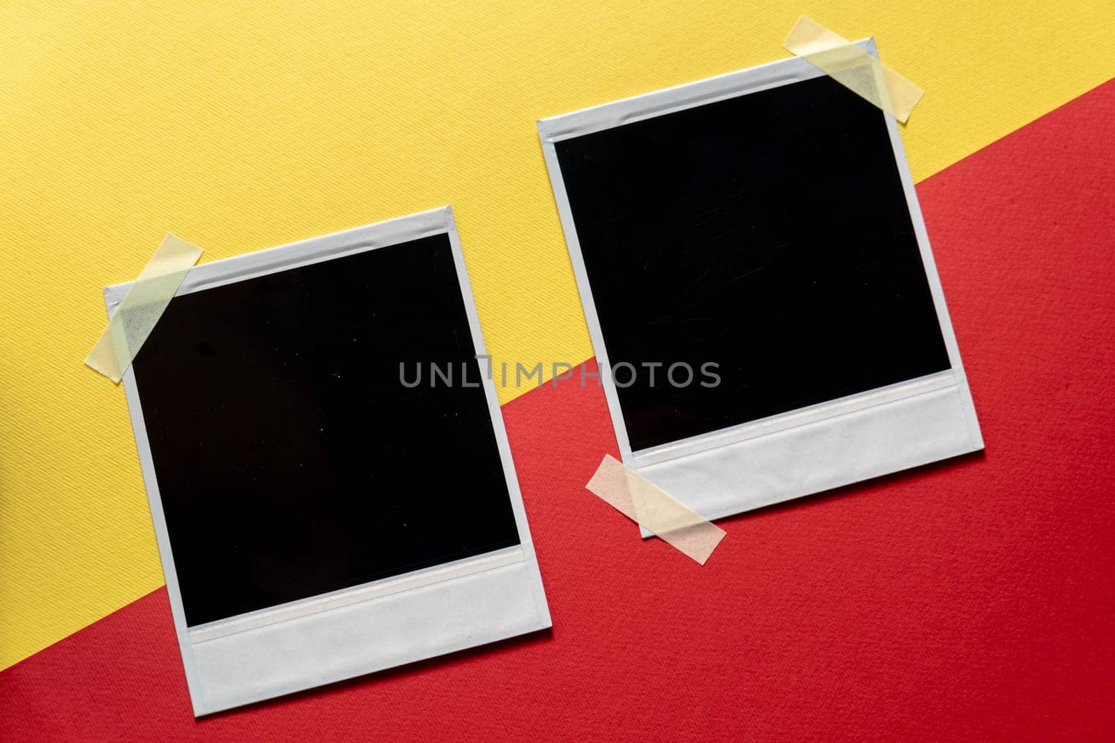 Download Blank photo frames template on red and yellow background. Blank square photo frames with tape on wall copy space by igor010