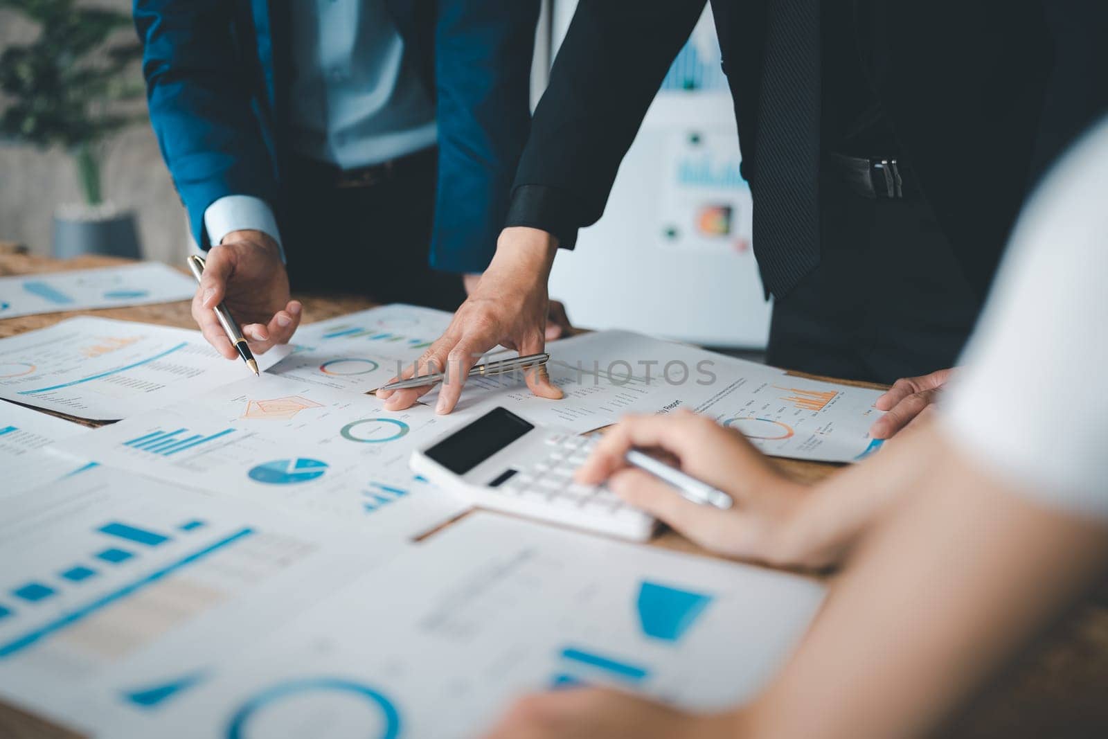 Accountant checking financial statement or counting by calculator income for tax form, Business woman sitting and working with colleague discussing the desk in office. Audit concept by Manastrong