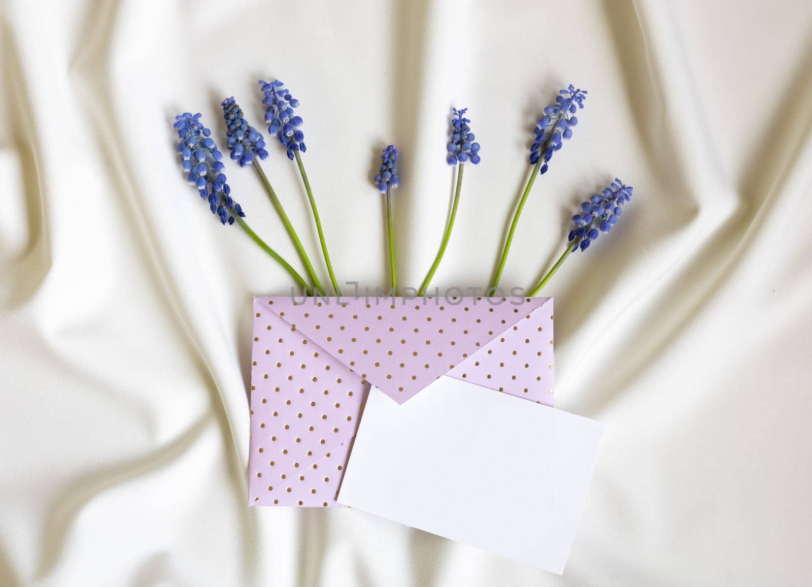 Invitation or greeting card mockup with envelope, muscari flowers. Blank card mockup on white folded background. by Ri6ka