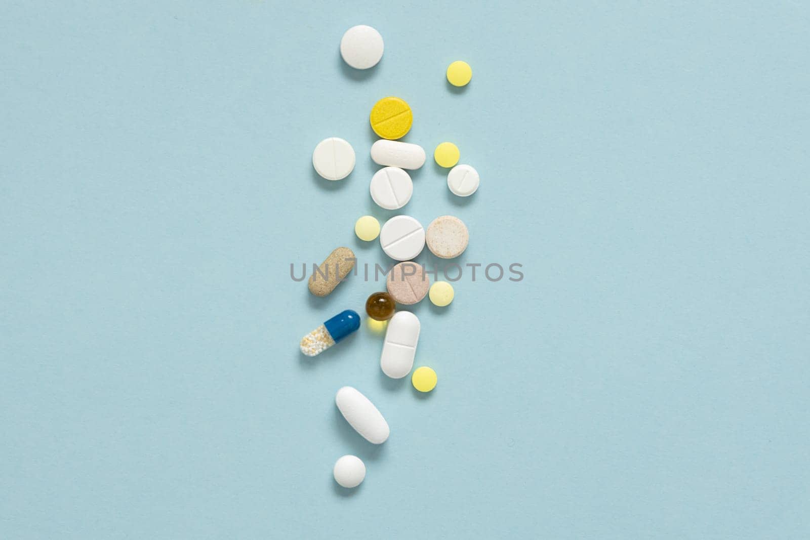 A lot of colorful medicine pills on pastel blue background by Ri6ka