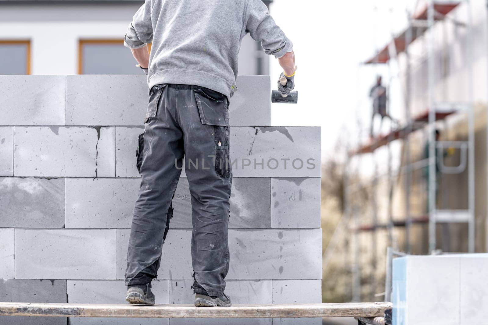 a mason builds the wall of a building from concrete bricks and blocks. High quality photo