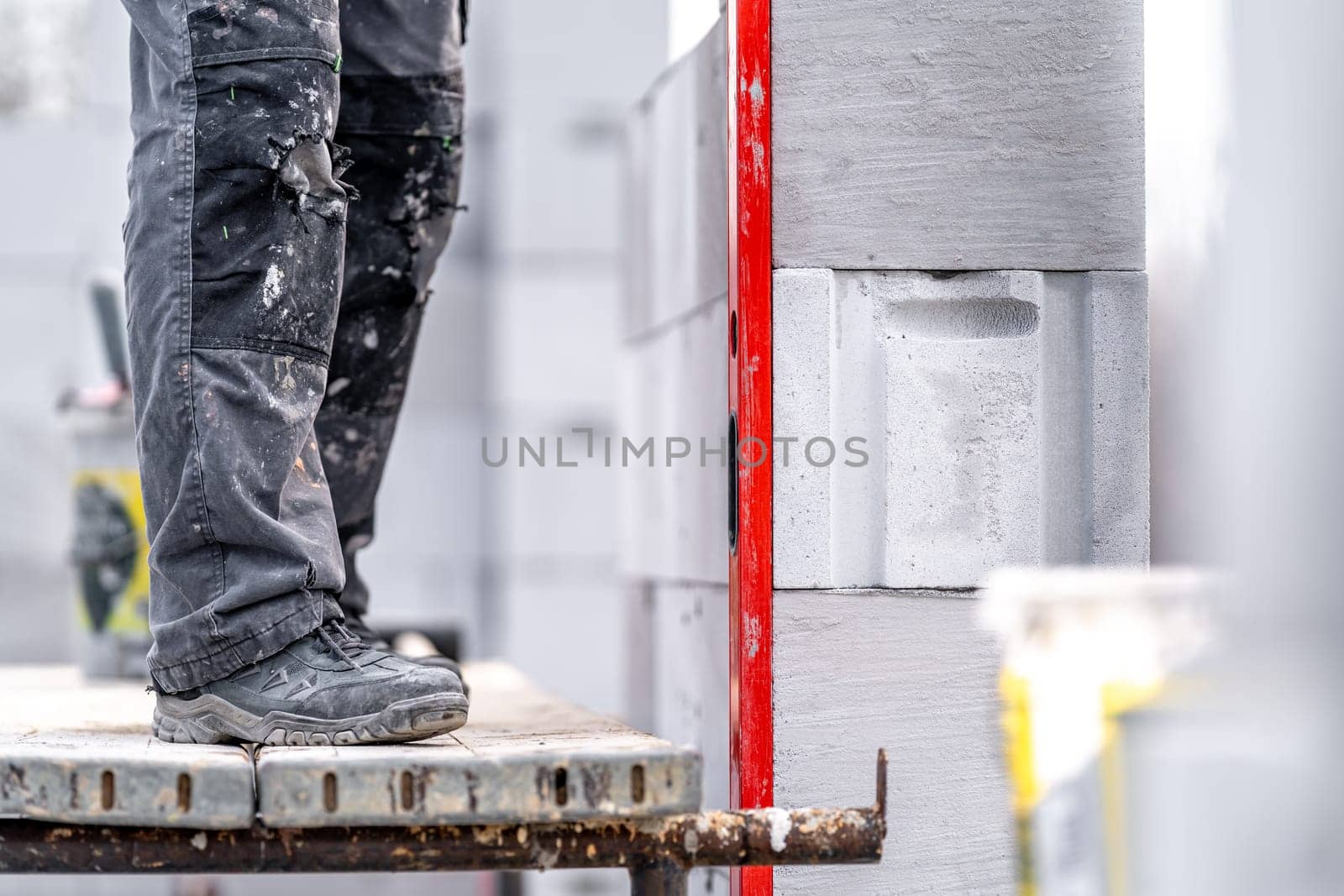 leveling bricks with the help of a spirit level during the construction of the wall of the house.