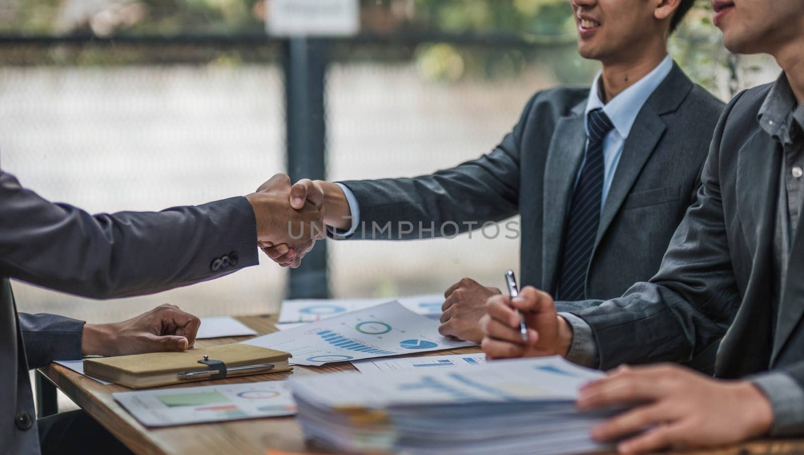 Business handshake for teamwork of business merger and acquisition,successful negotiate,hand shake,two businessman shake hand with partner to celebration partnership and business deal concept. by wichayada