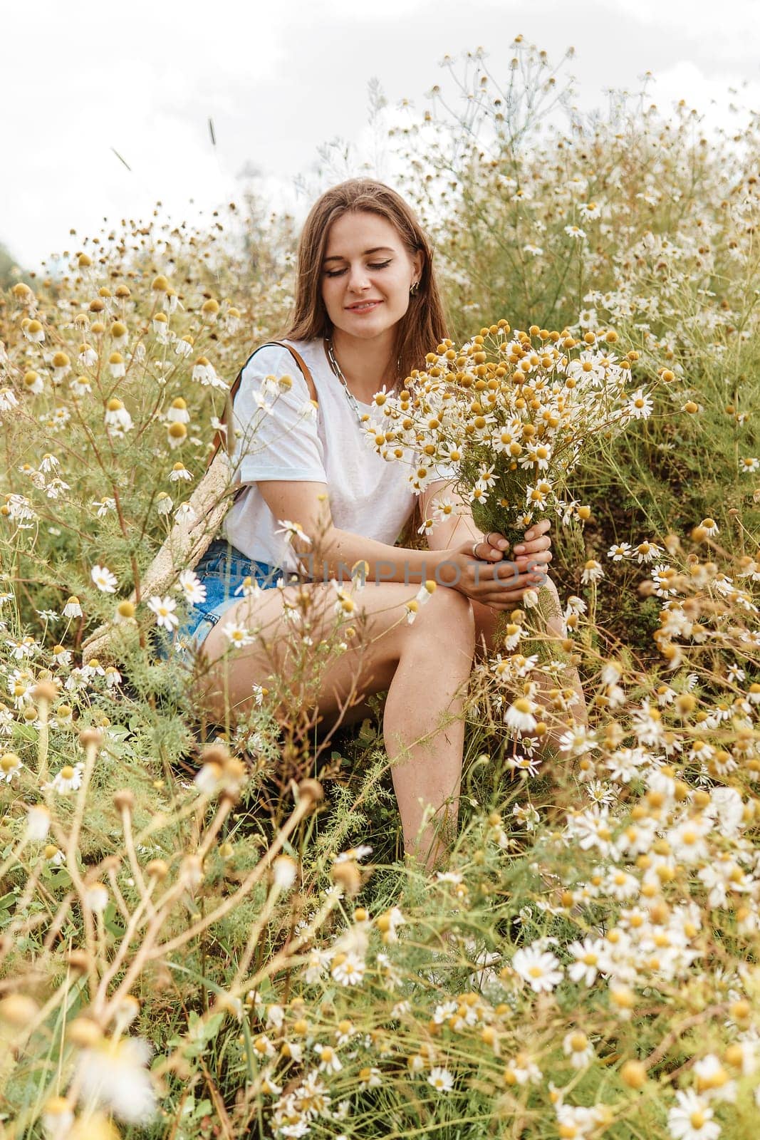 Beautiful young woman in nature with a bouquet of daisies. Field daisies, field of flowers. by Annu1tochka