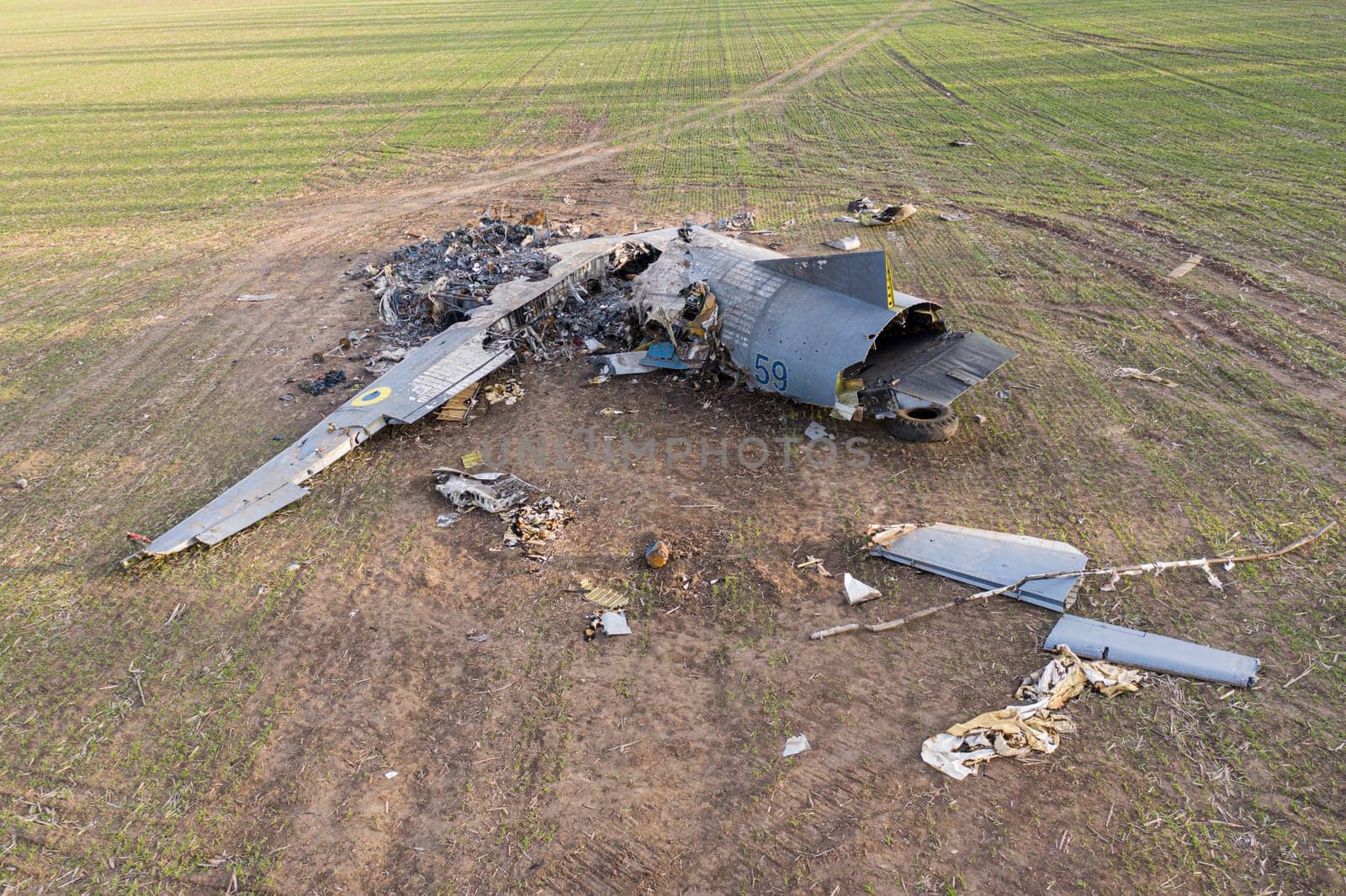 In this picture, an AN-26 aircraft can be seen lying on a field in Ukraine after an accident. The aircraft appears to have suffered significant damage, with parts scattered around the wreckage. The image conveys the severity of the accident and the potential dangers of aviation during the war