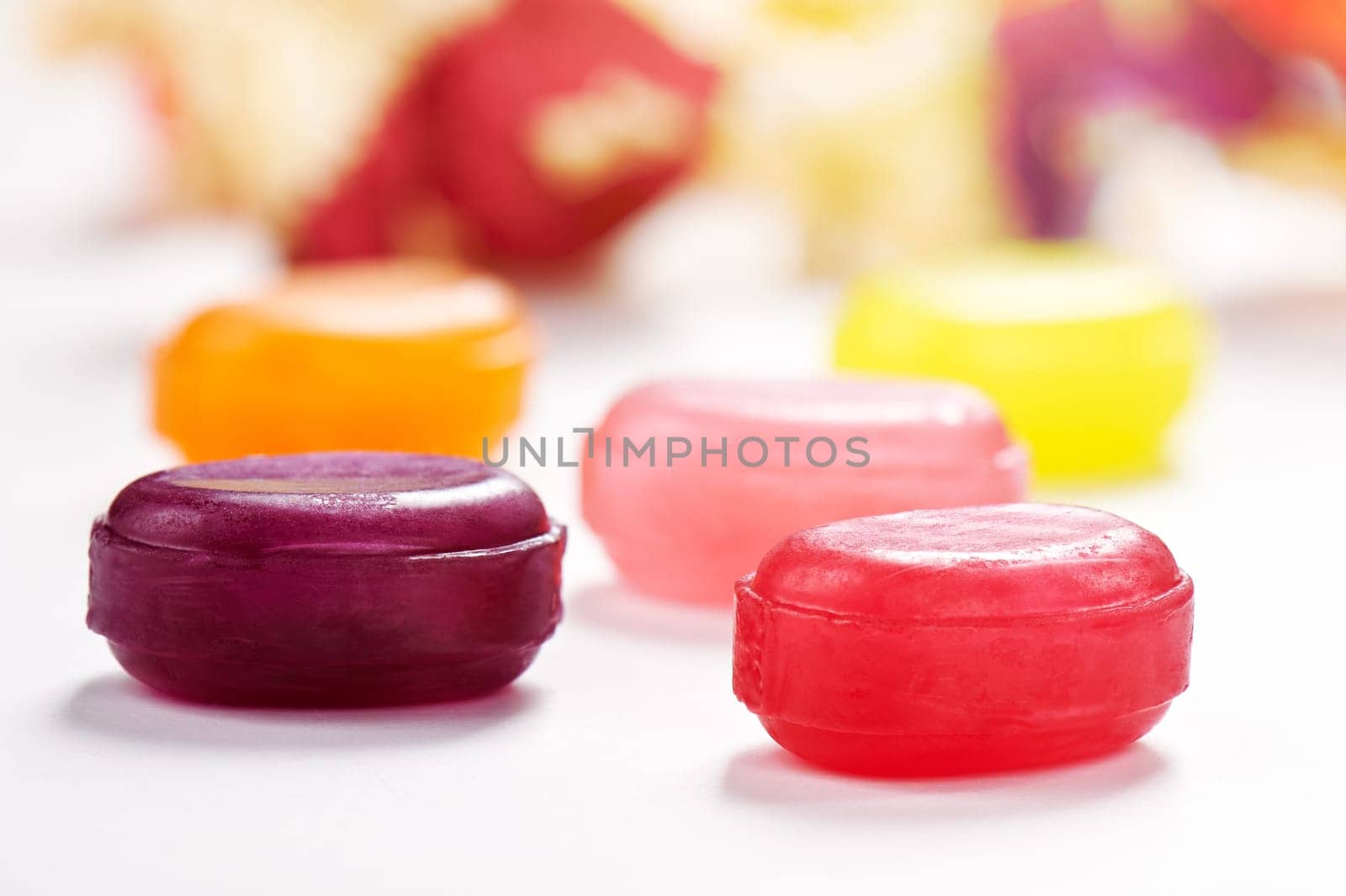 Several colorful lollipop candies closeup on white surface by maxcab