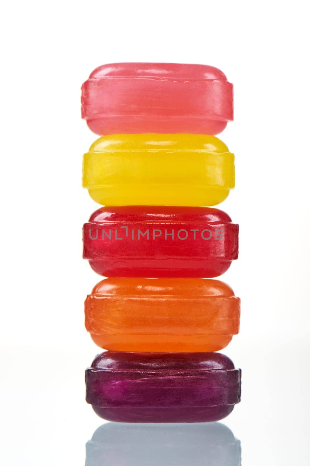 Stack colorful hard lollipop candies closeup on white background