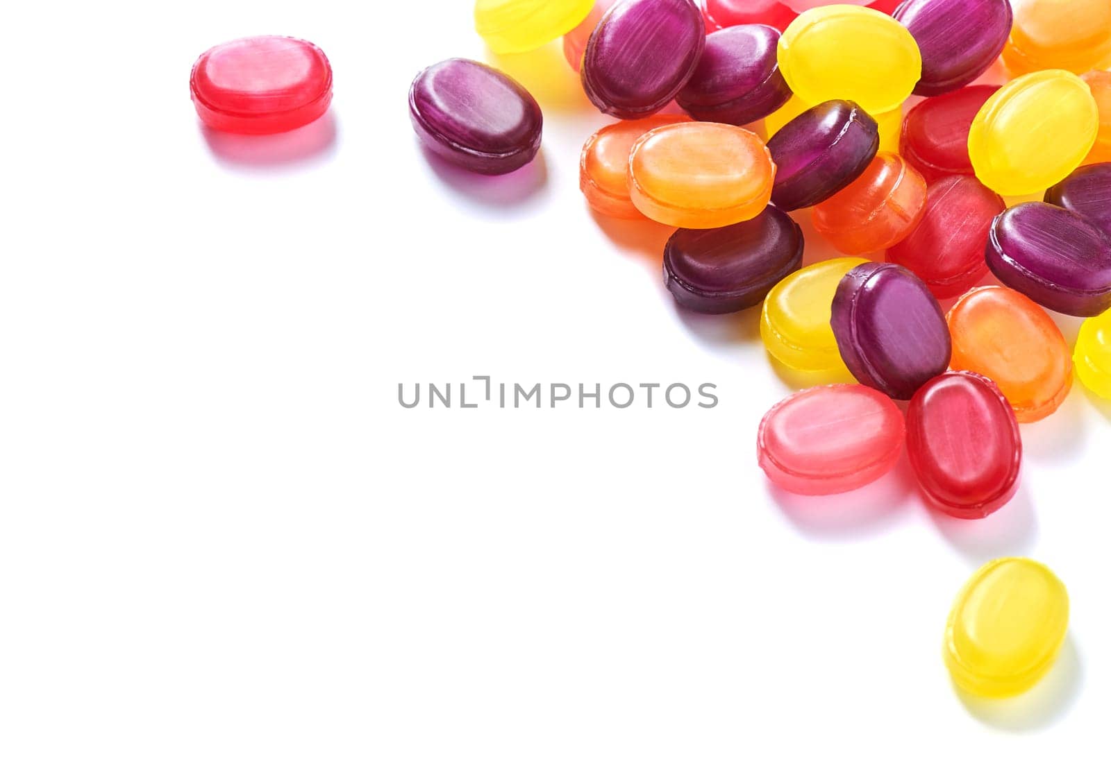 Pile colorful hard lollipop candies closeup on white background