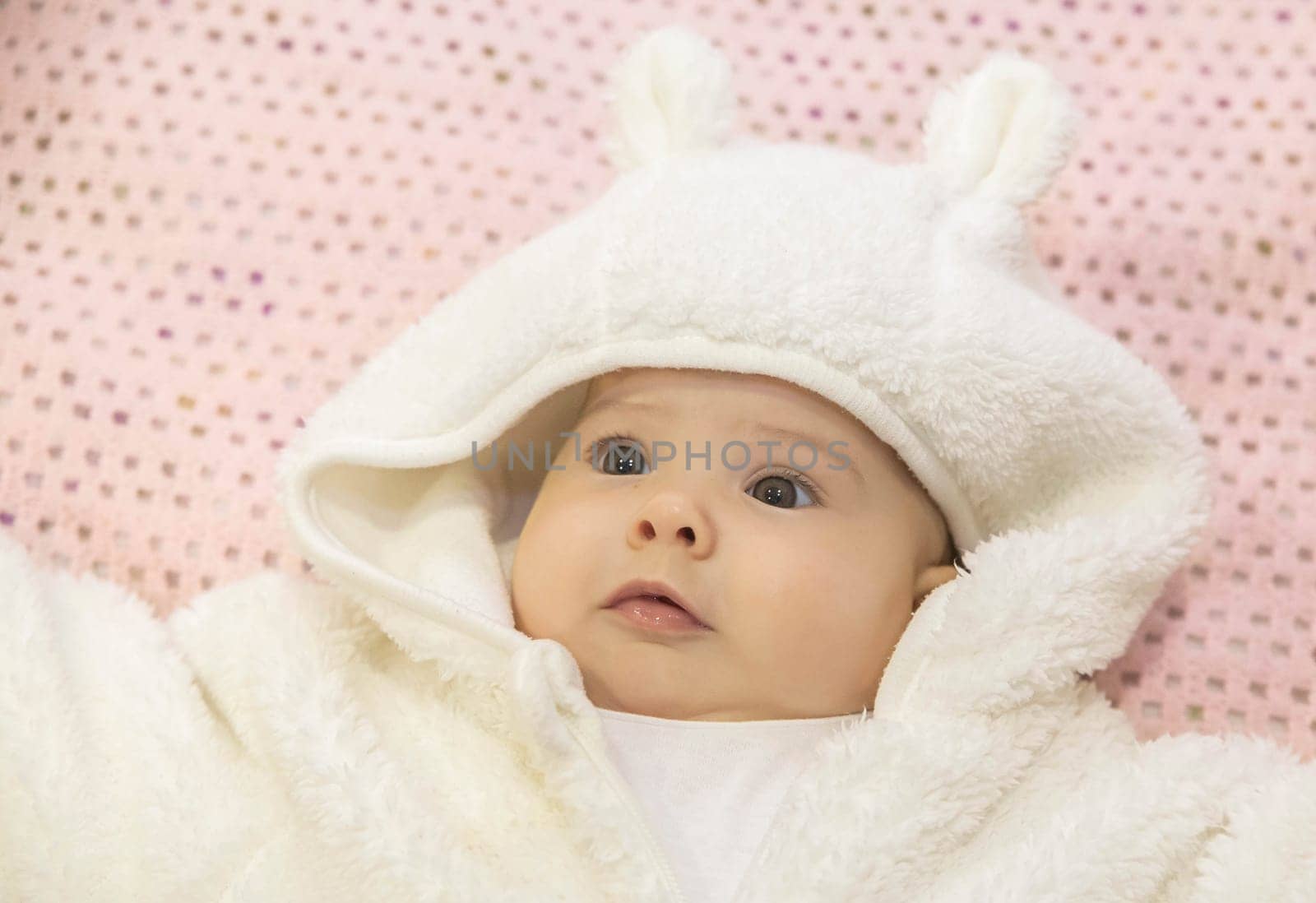 cute baby lying in a white hare costume.