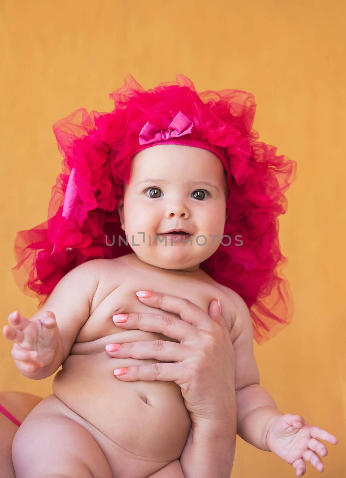 Mother holds beautiful newborn daughter with one hand.