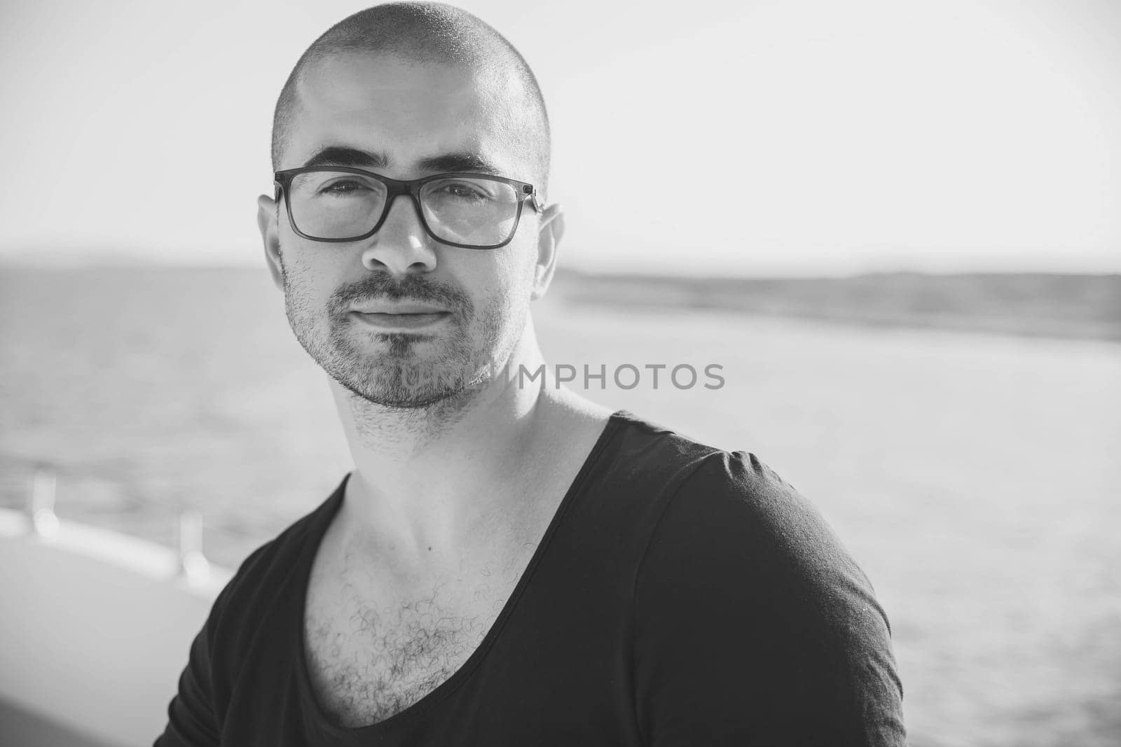 attractive guy with glasses resting on a yacht.